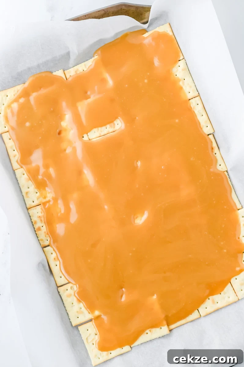 Butter and brown sugar mixture is spread on top of saltine crackers.