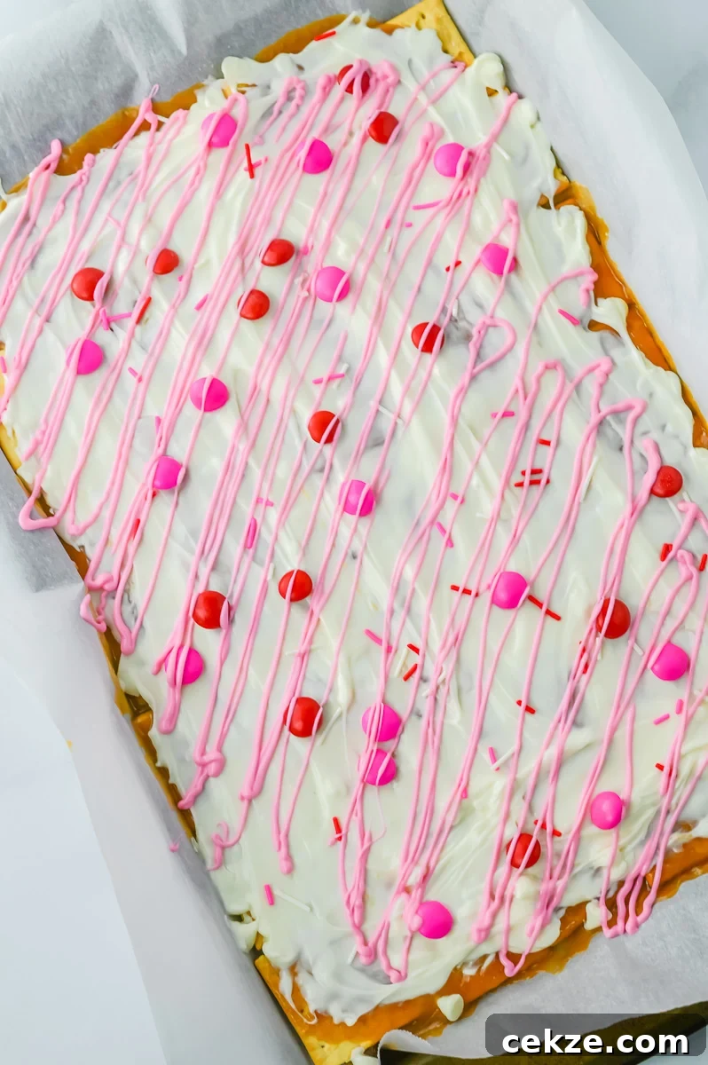 Pink white chocolate drizzle is added to the top of the cracker candy.