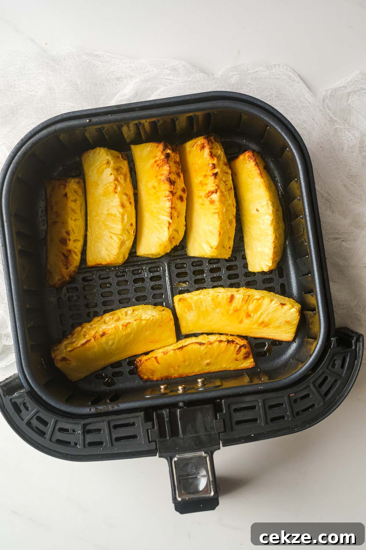 top down view of pineapple in air fryer basket