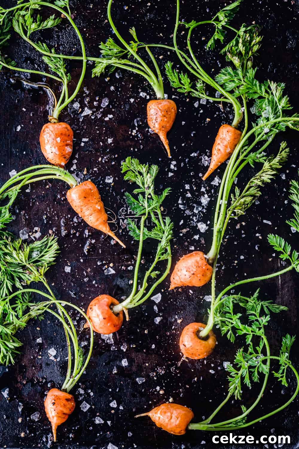 raw baby carrots with olive oil, salt and pepper on a baking sheet to be used in the farmers market salad