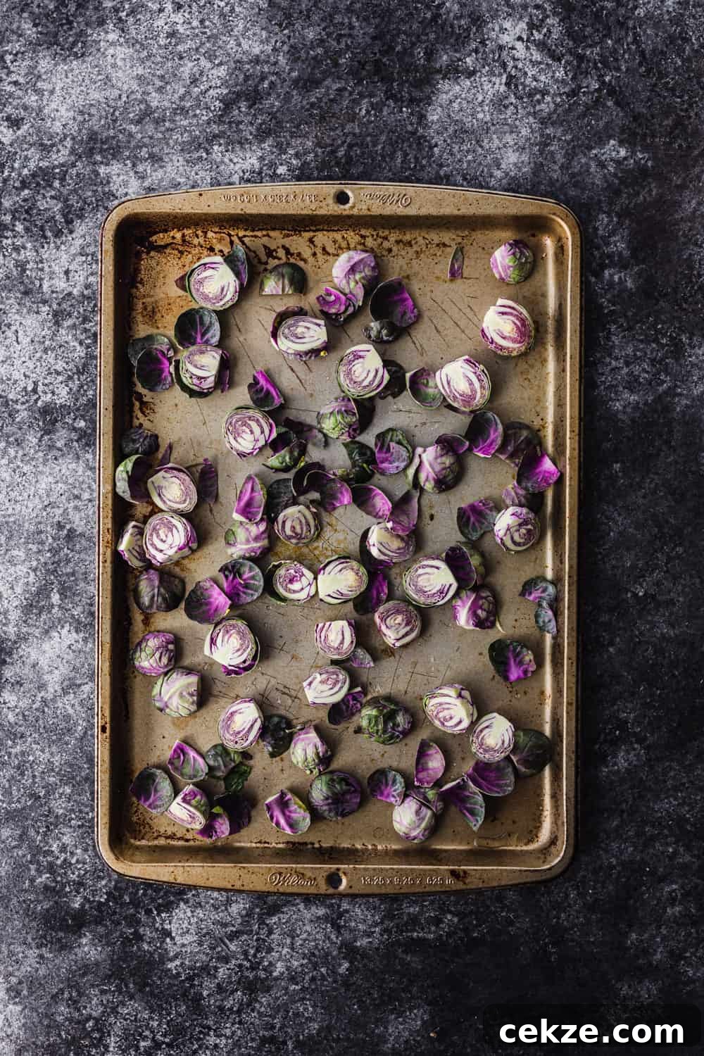 raw Brussels sprouts cut in half on a baking sheet to be used in the farmers market salad