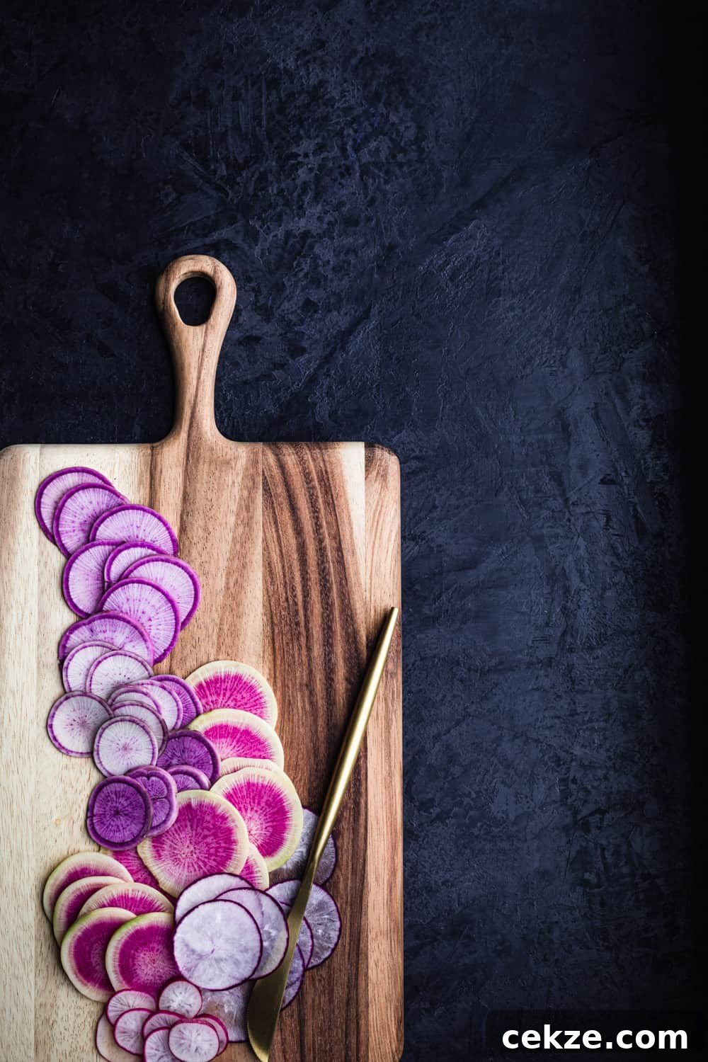farmers market salad ingredient shot of radishes thinly sliced on a cutting board with a gold knife