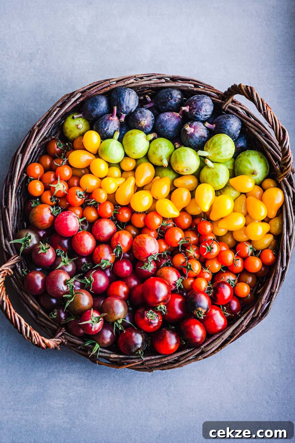 Colorful cherry tomatoes and figs in a basket.