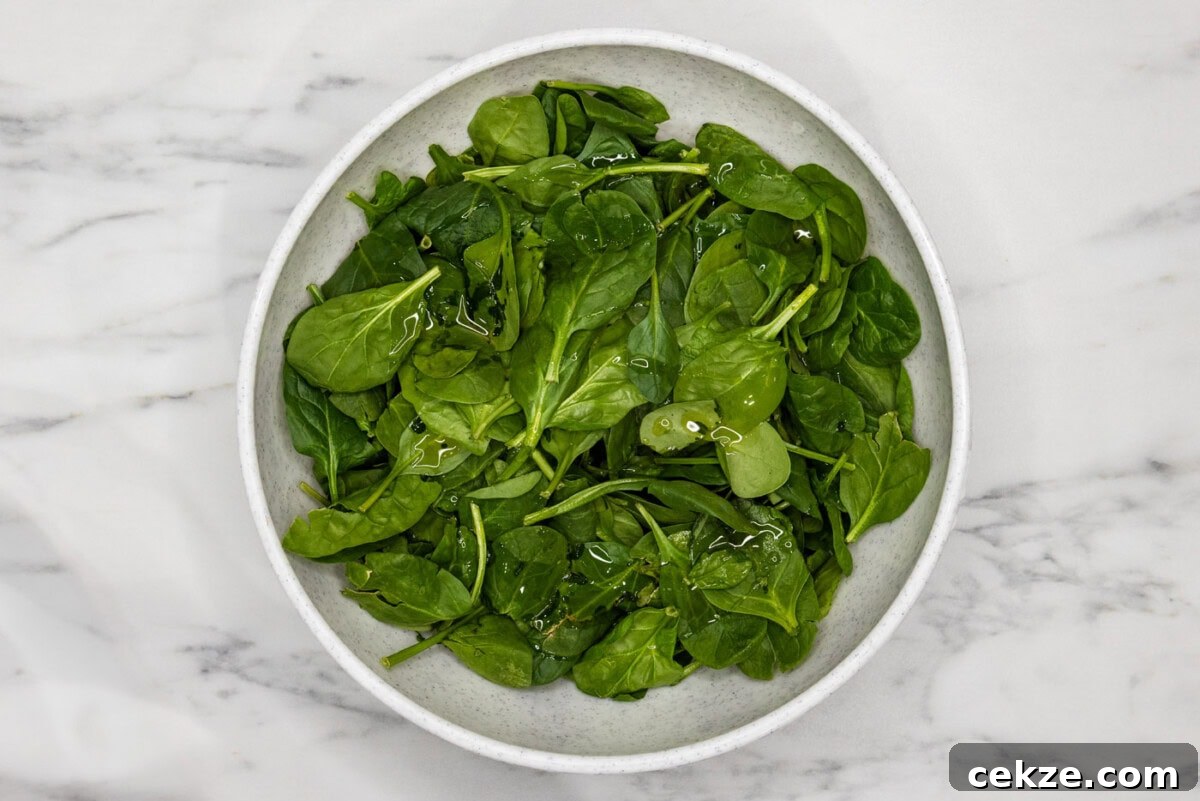 spinach in a bowl tossed with oil
