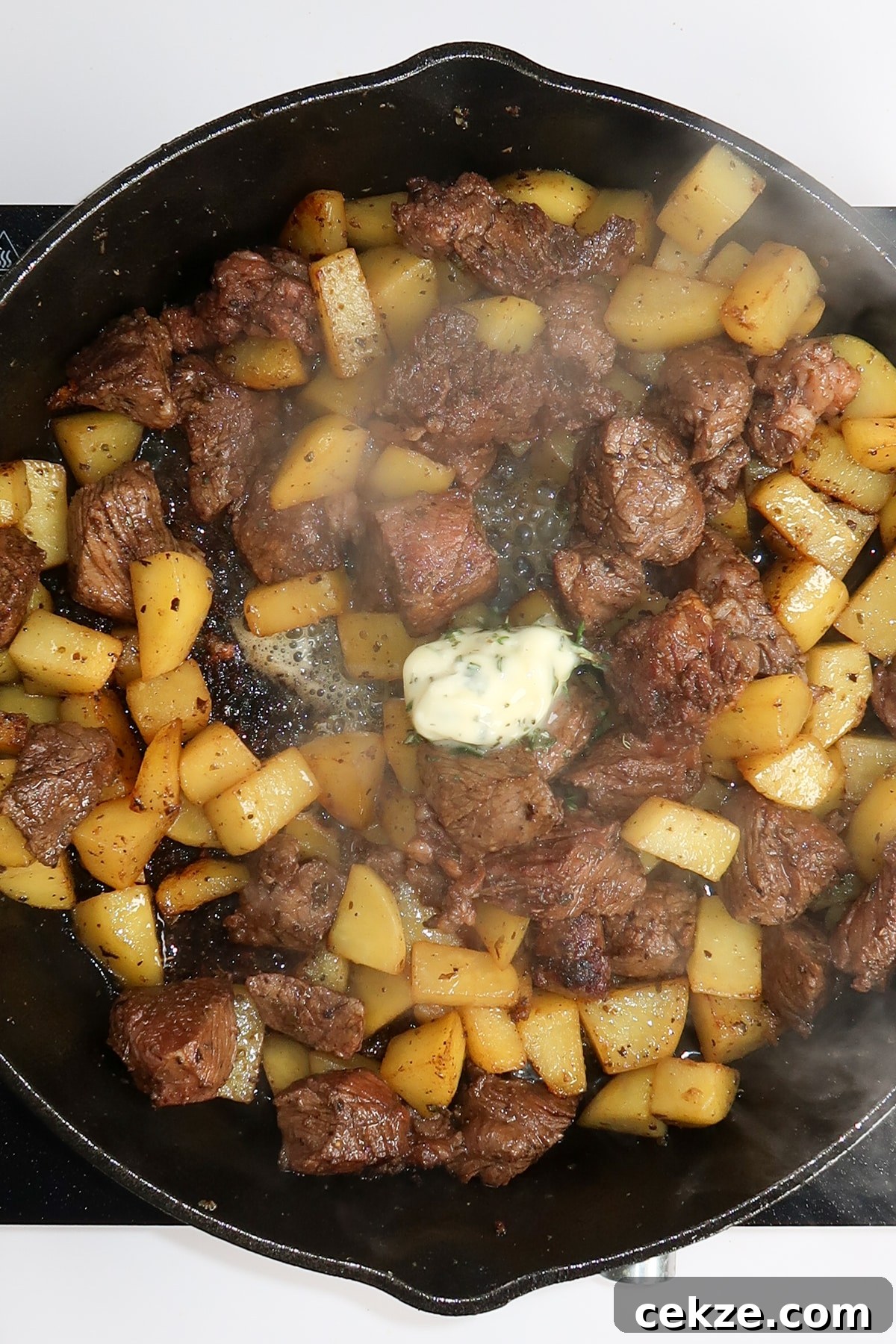 Garlic Butter Steak and Potatoes Skillet Recipe for Weeknights 7 garlic butter on top of the cooked potatoes and steak before mixing everything together in the skillet.