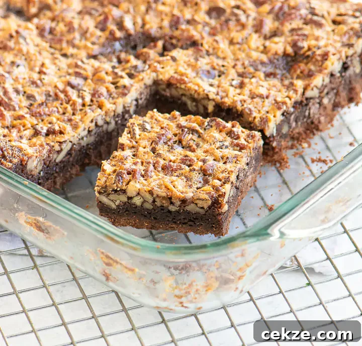 Chocolate Pecan Pie Bars Recipe — Fudgy Chocolate Pecan Bars 2 sliced pecan pie bars in a glass baking dish set on a wire rack
