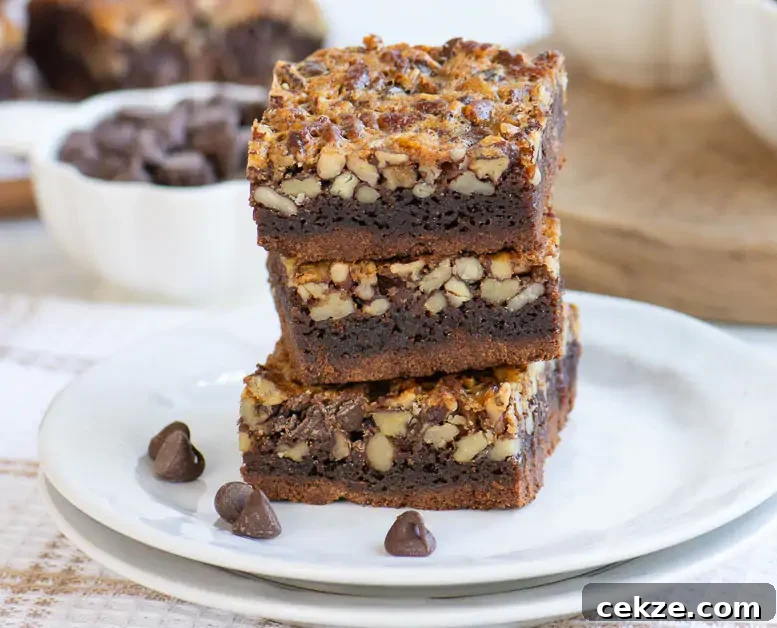 Chocolate Pecan Pie Bars Recipe — Fudgy Chocolate Pecan Bars 5 stack of three bars on a white plate in front of a small white dish of chocolate chips