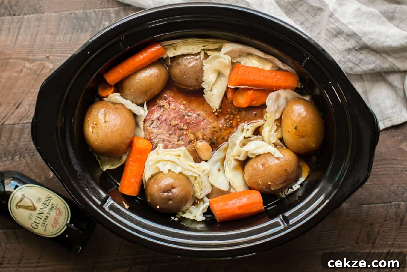corned beef in slow cooker with potatoes, carrots and cabbage, done cooking.