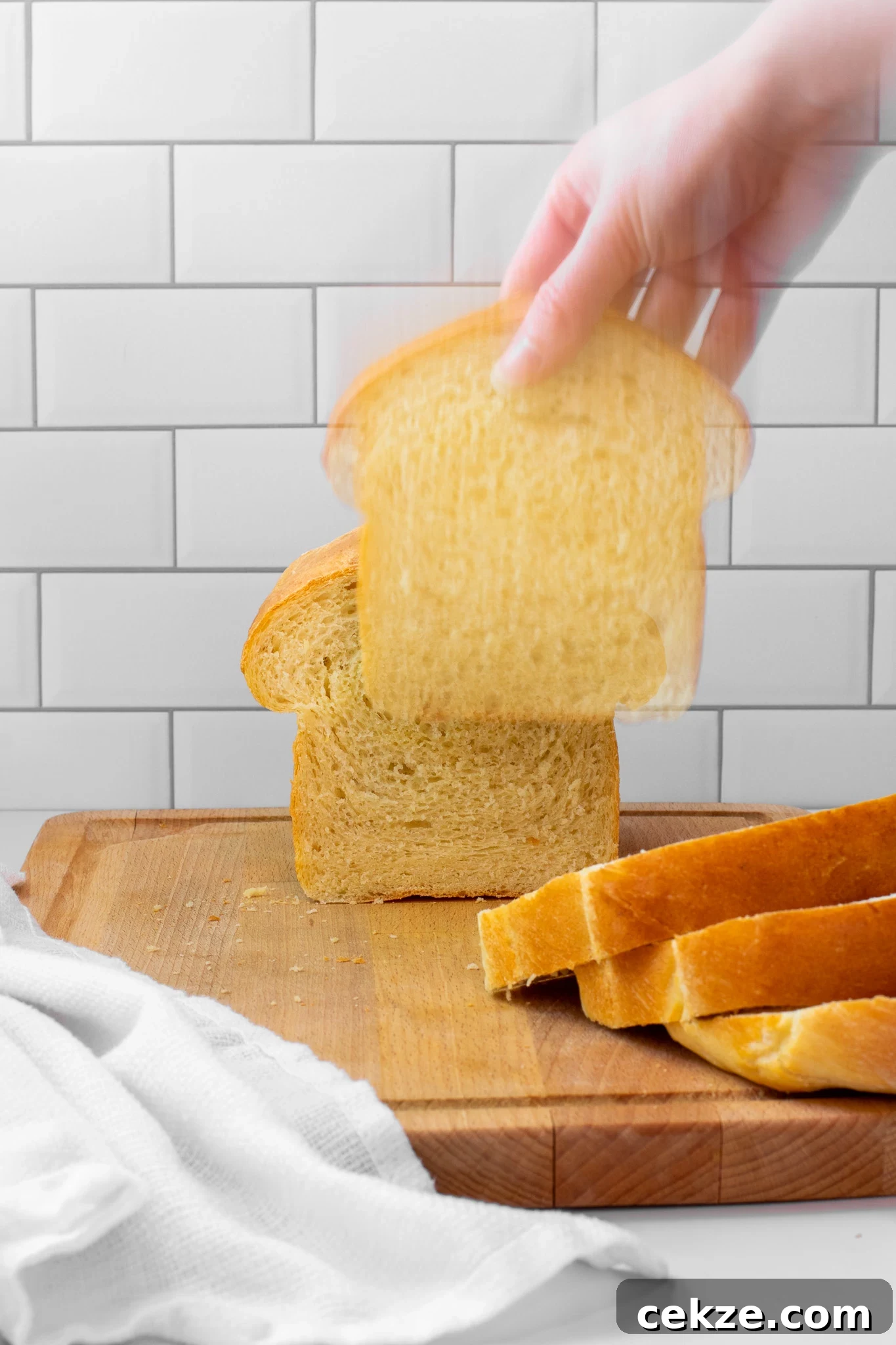 Grabbing a piece of bread from a potato loaf.