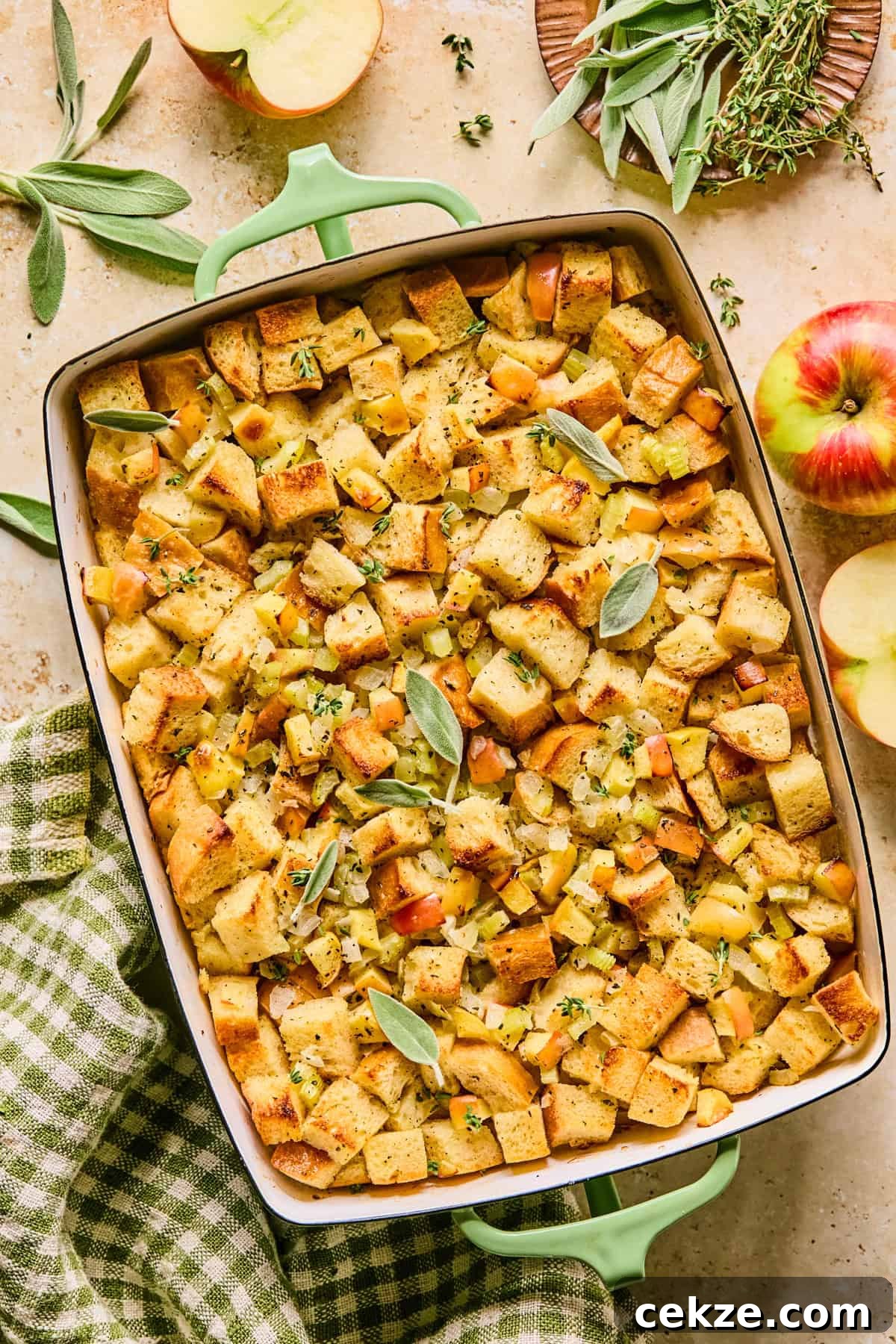 Apple and Sage Stuffing Recipe with Crispy Herbs 2 Apple stuffing in baking pan with chopped herbs and fresh sage on top.