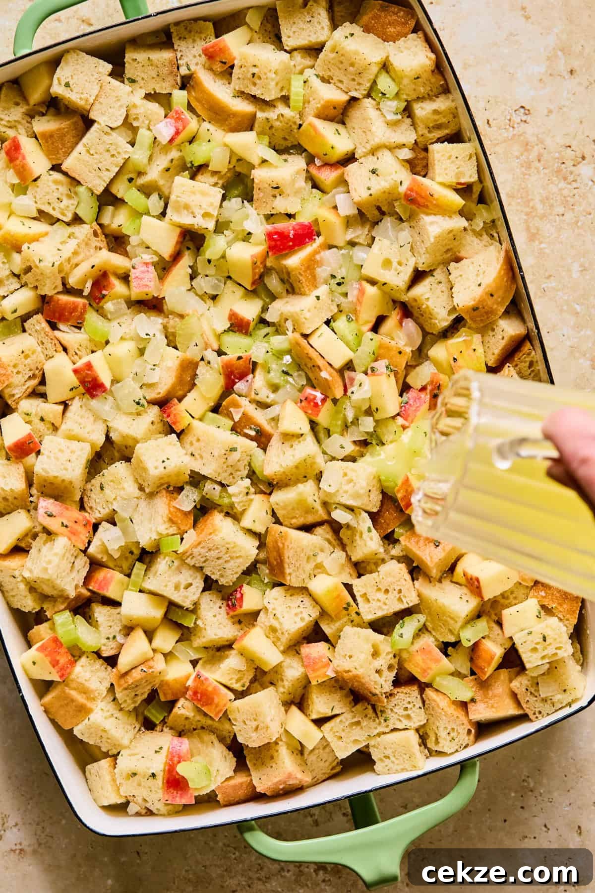 Apple and Sage Stuffing Recipe with Crispy Herbs 11 Butter poured over top of stuffing mixture in pan.