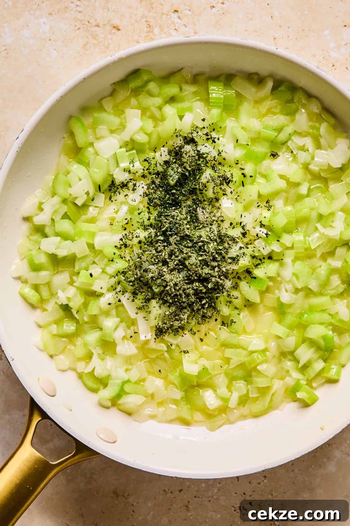 Apple and Sage Stuffing Recipe with Crispy Herbs 6 Butter, celery, onion and fresh herbs in pan.