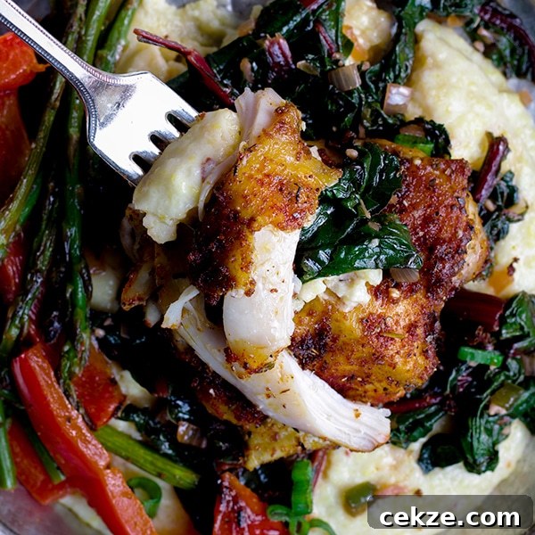 Taking a bite of Sheet Pan Cajun Chicken with Vegetables and Cheesy Grits