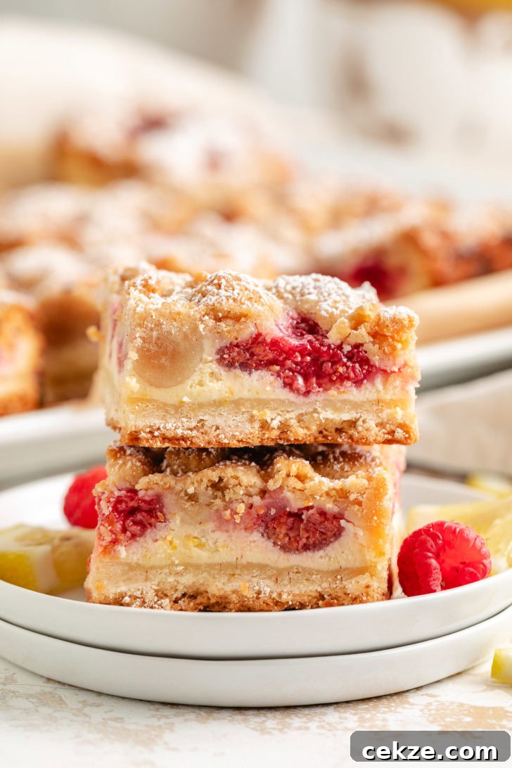 Two lemon raspberry crumble bars stacked on plates.