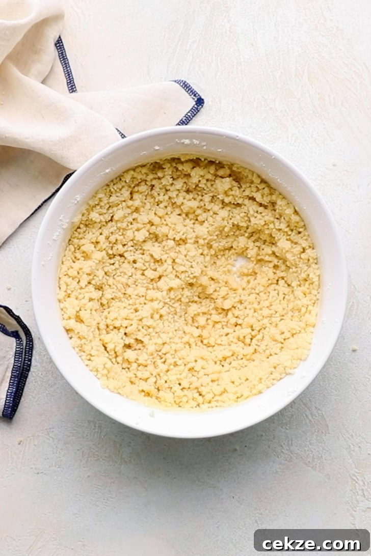 Dough for a shortbread crust mixed together in a white bowl.
