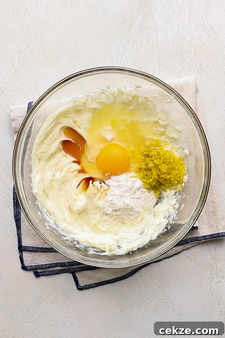 Ingredients for creamy lemon filling used in lemon raspberry crumb bars in a glass bowl.