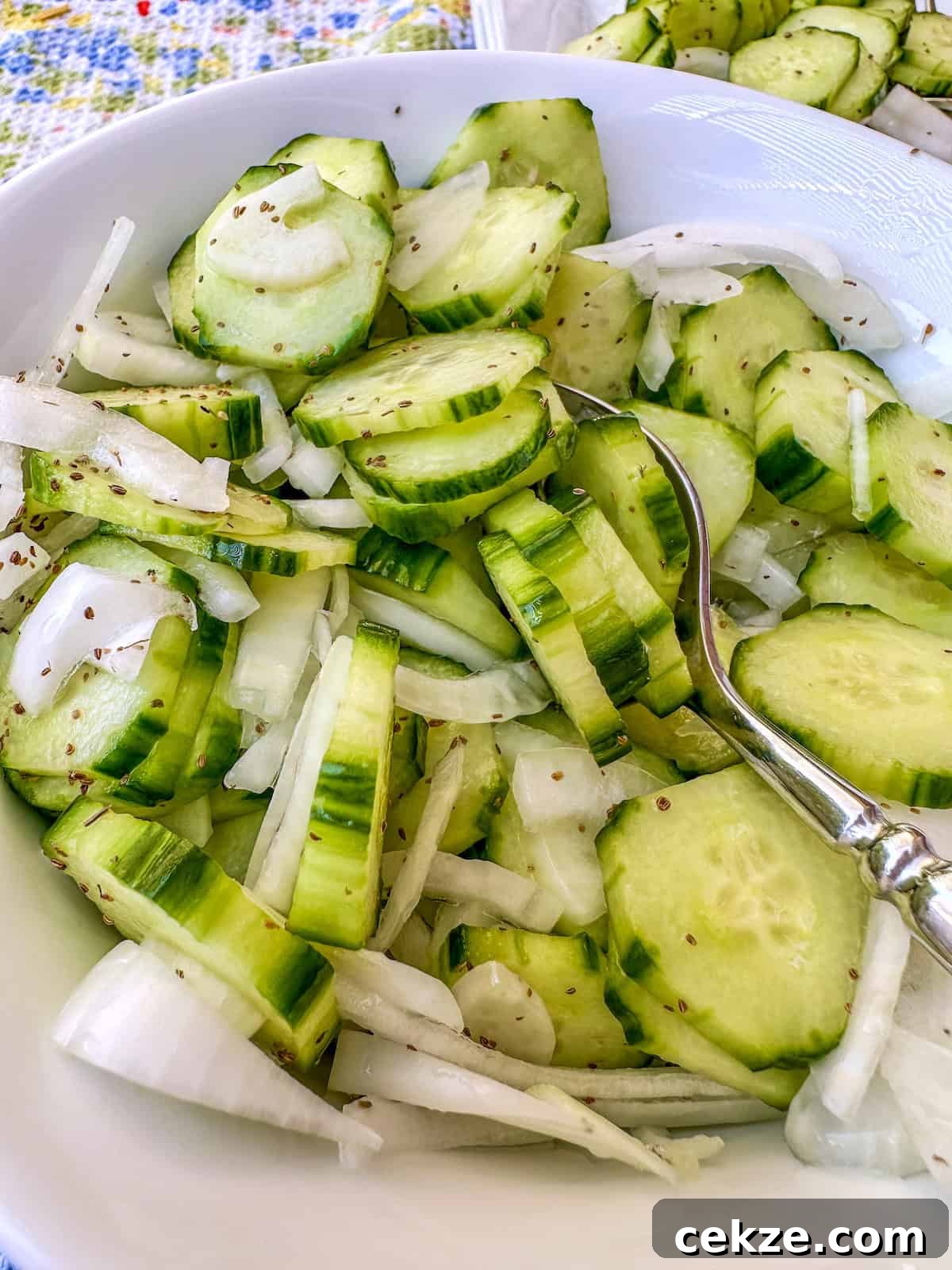 Crisp Quick Refrigerator Pickled Cucumbers in 30 Minutes 11 A bowl of quick pickled cucumbers with sliced onions in a bowl.