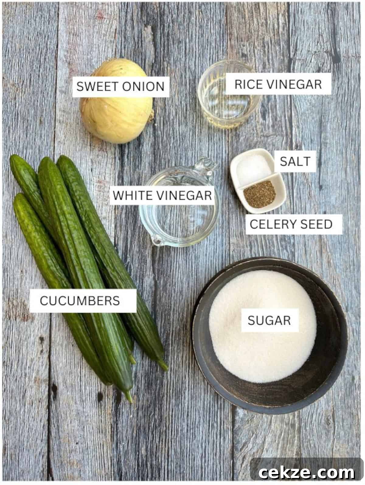 Crisp Quick Refrigerator Pickled Cucumbers in 30 Minutes 4 Labeled ingredients for refrigerator pickles on a wooden table.