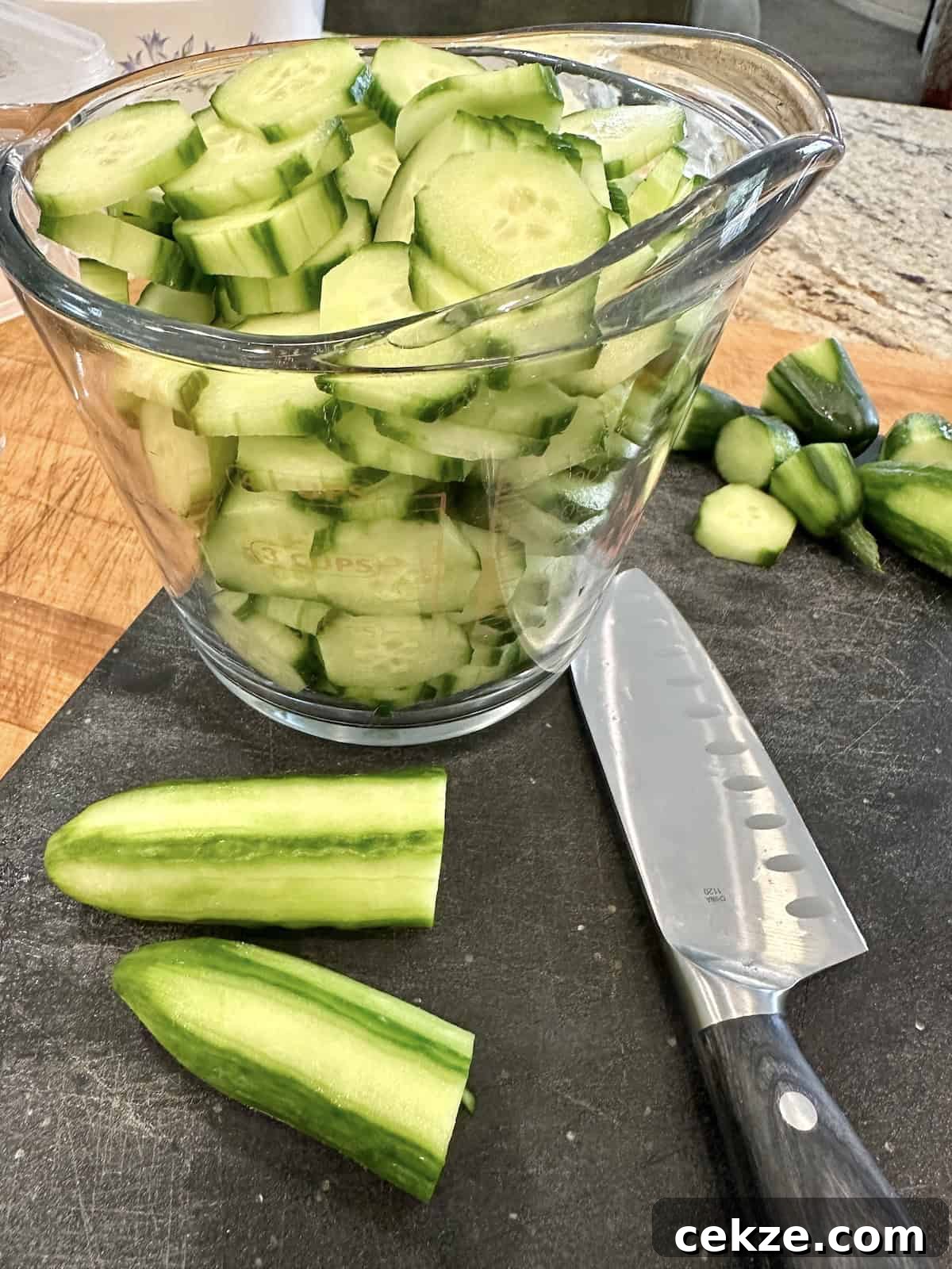 Crisp Quick Refrigerator Pickled Cucumbers in 30 Minutes 5 Sliced cucumbers in a measuring cup.
