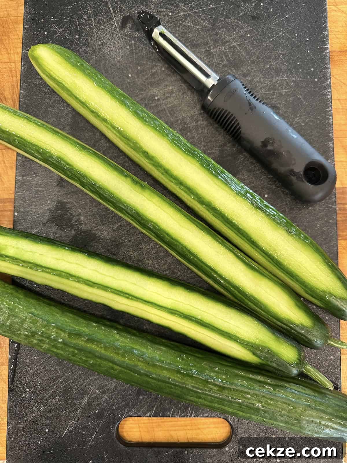 Crisp Quick Refrigerator Pickled Cucumbers in 30 Minutes 7 Cucumbers half peeled for refrigerator pickles.