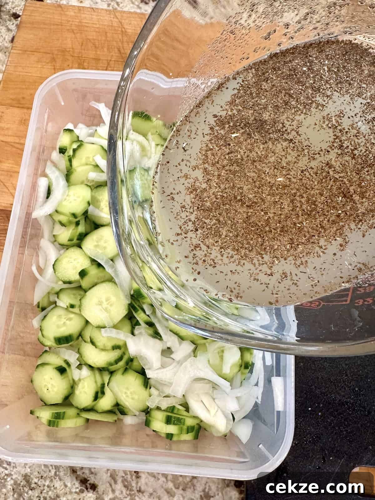 Crisp Quick Refrigerator Pickled Cucumbers in 30 Minutes 9 Pouring brine over cucumber and onion slices.