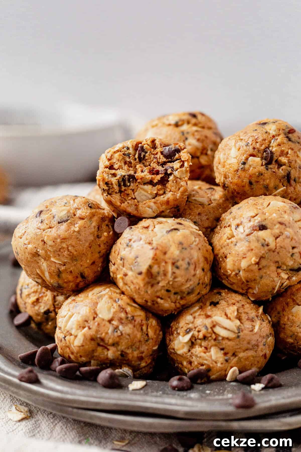 a bite taken out of the top oatmeal peanut butter protein ball on a serving plate