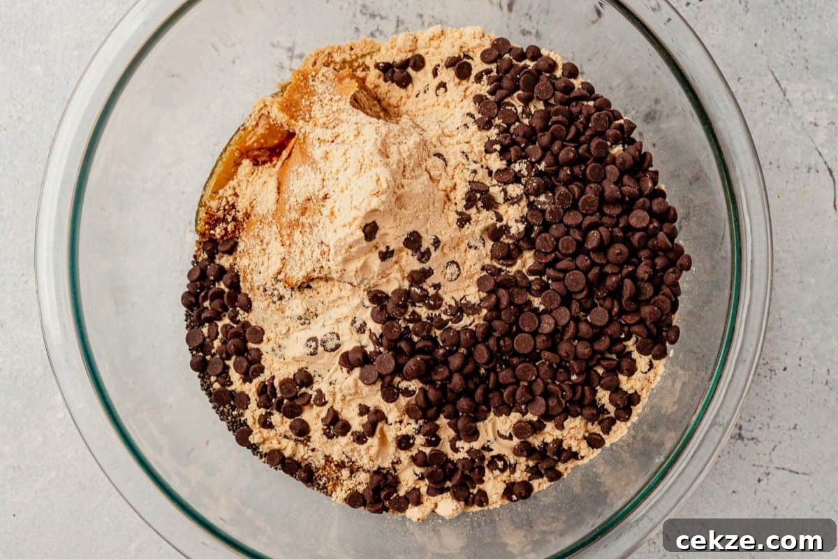 oats, peanut butter, protein powder, honey, chia seeds, and chocolate chips in a mixing bowl