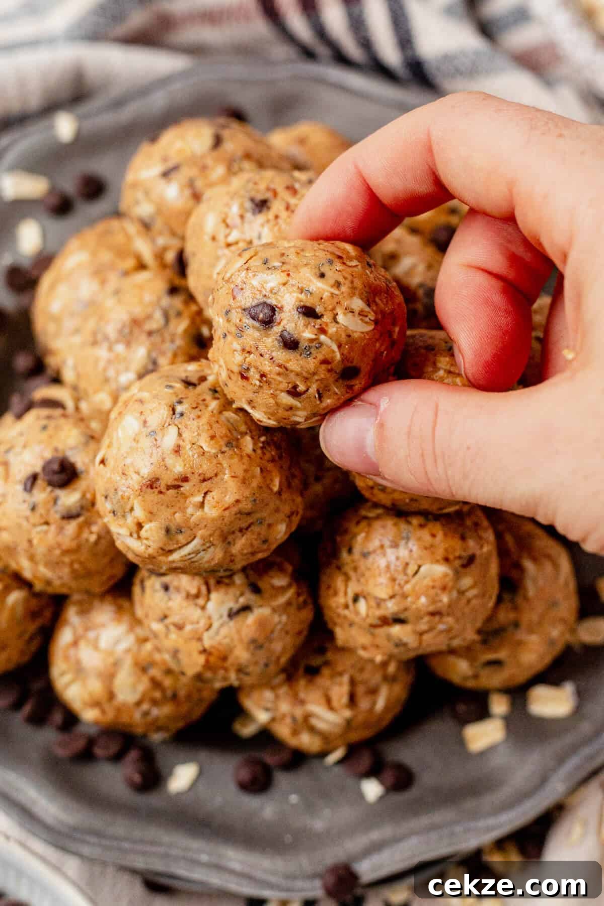 picking an oatmeal peanut butter protein ball off the top of a stack