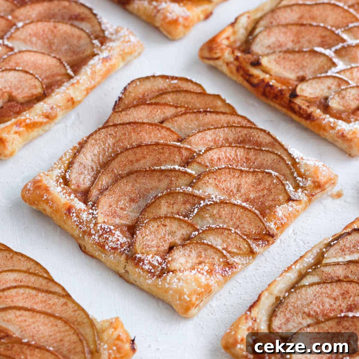 Puff Pastry Pear Tartlets with Honey and Almonds 2 Close up on one pear tartlet on a white surface.