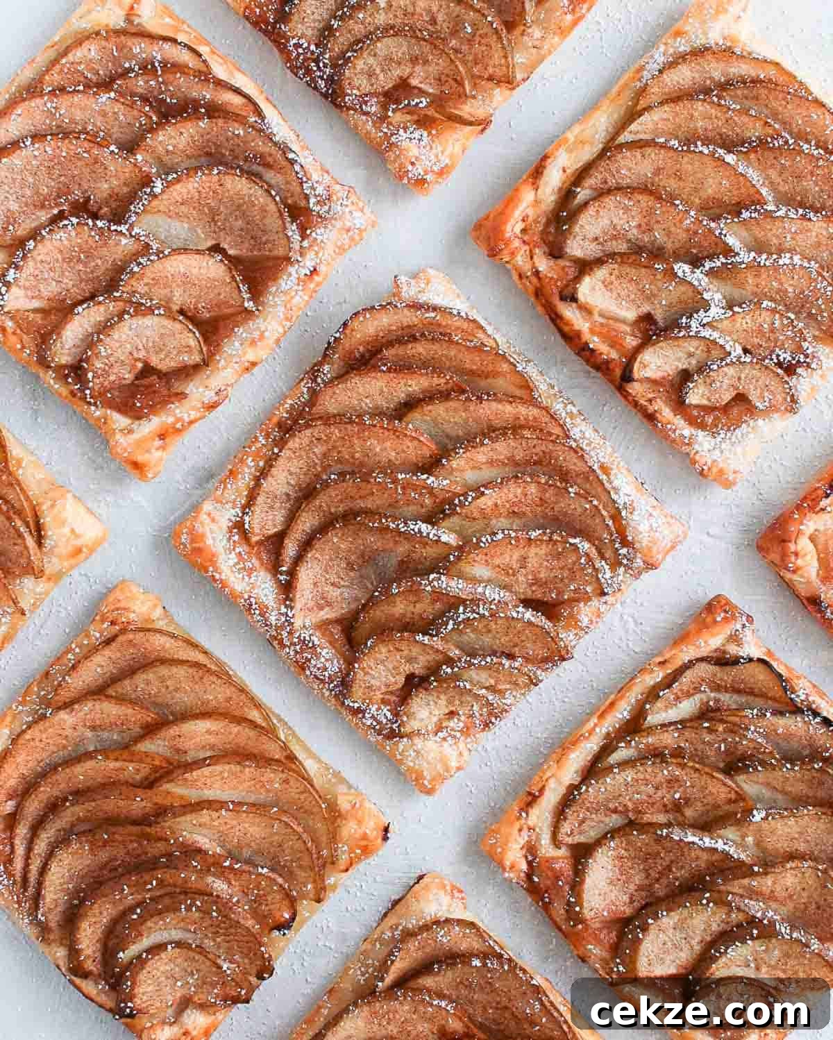 Puff Pastry Pear Tartlets with Honey and Almonds 6 Tartlets seen from above on a white surface.
