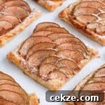 Puff Pastry Pear Tartlets with Honey and Almonds 8 Close up on one pear tartlet on a white surface.