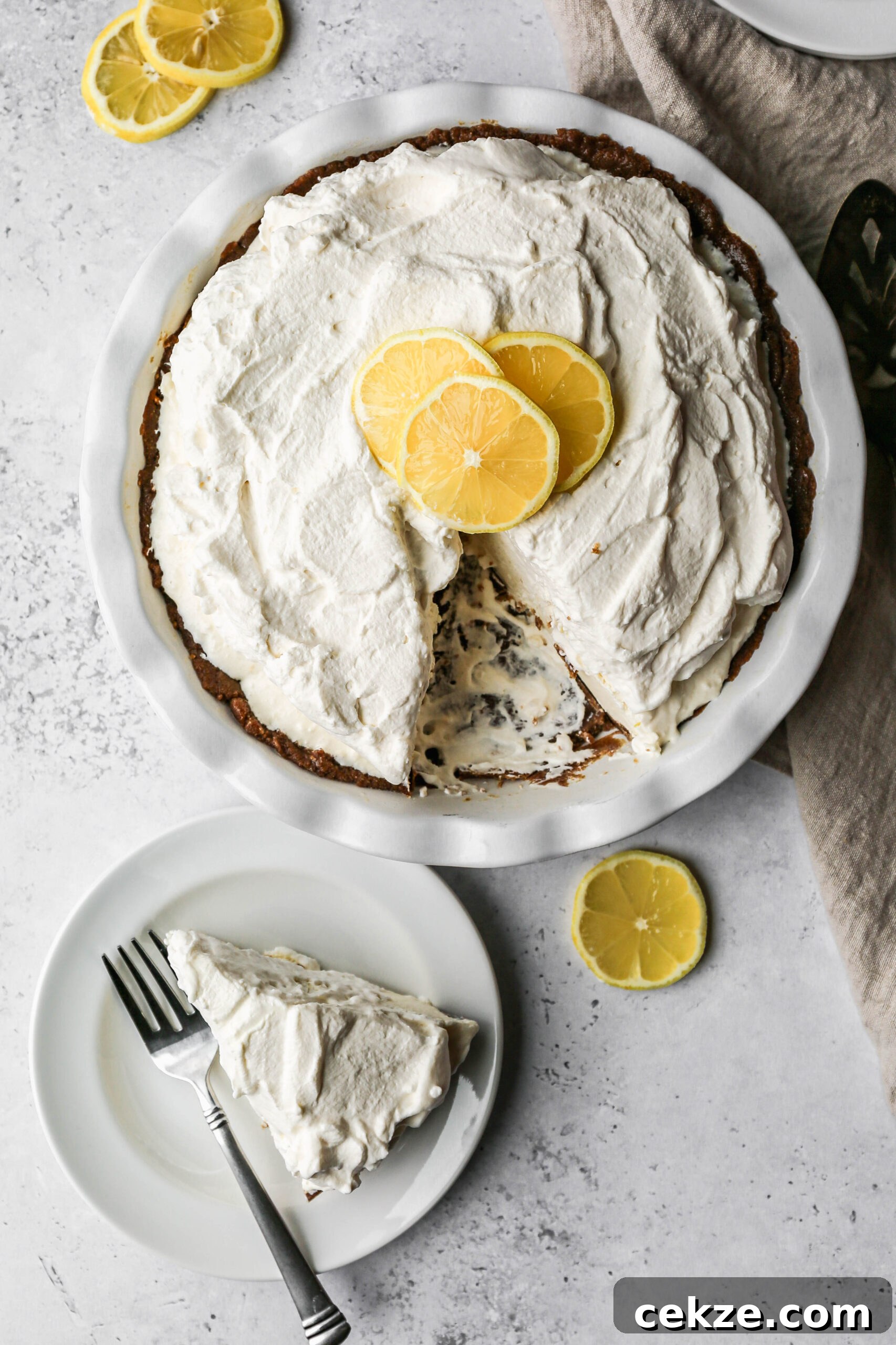 Gluten-Free No-Bake Lemon Icebox Pie Recipe 3 a white pie plate of gluten free no bake lemon icebox pie next to a slice on a white plate.