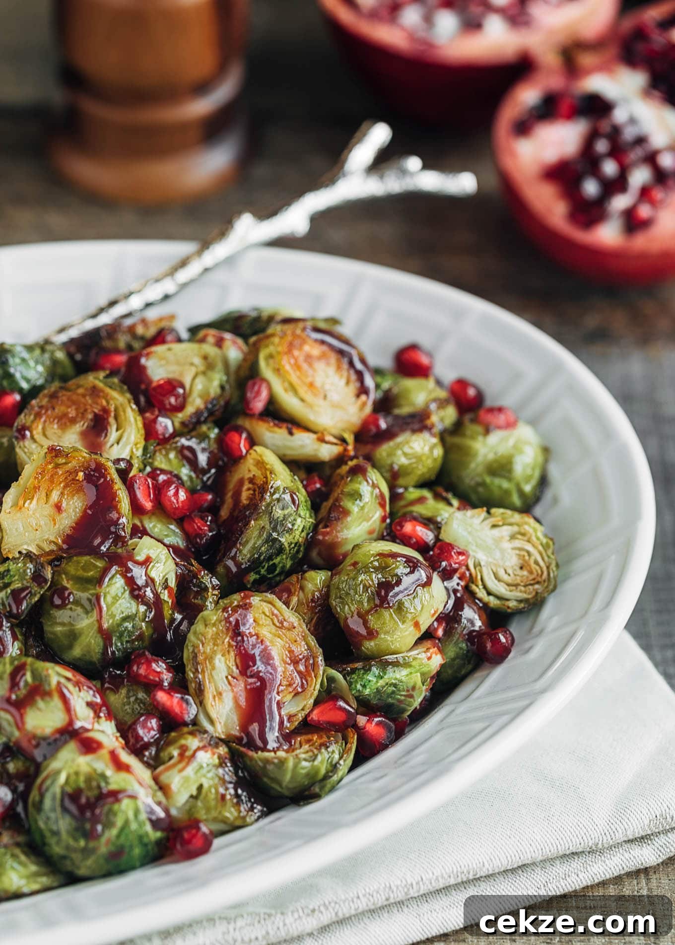 roasted brussels sprouts with pomegranate in a white serving dish