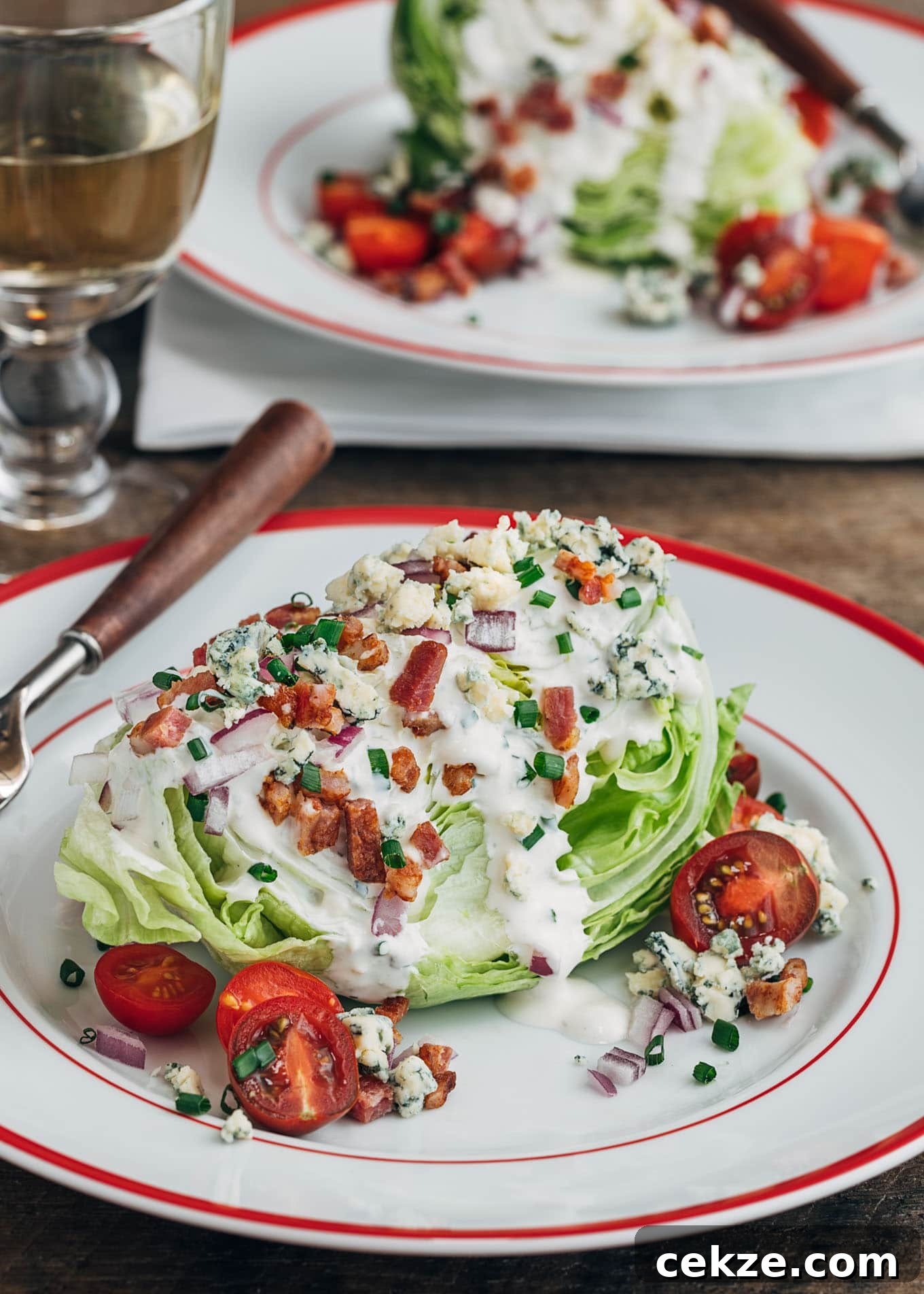 classic wedge salad with iceberg lettuce, bacon, and blue cheese dressing on a plate