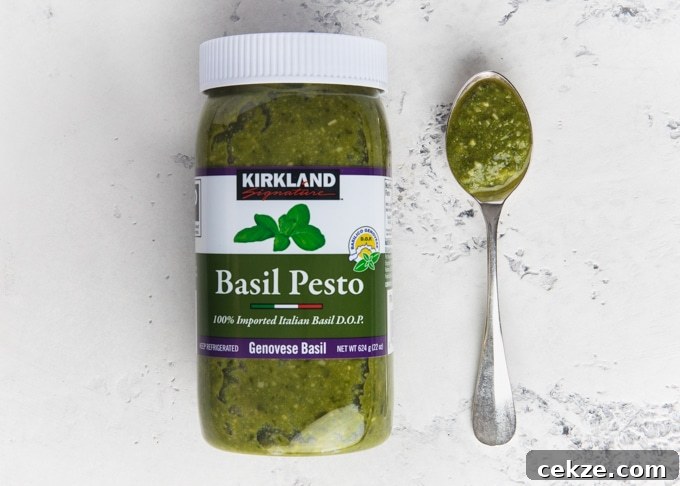 jar of kirkland basil pesto next to a spoonful of pesto