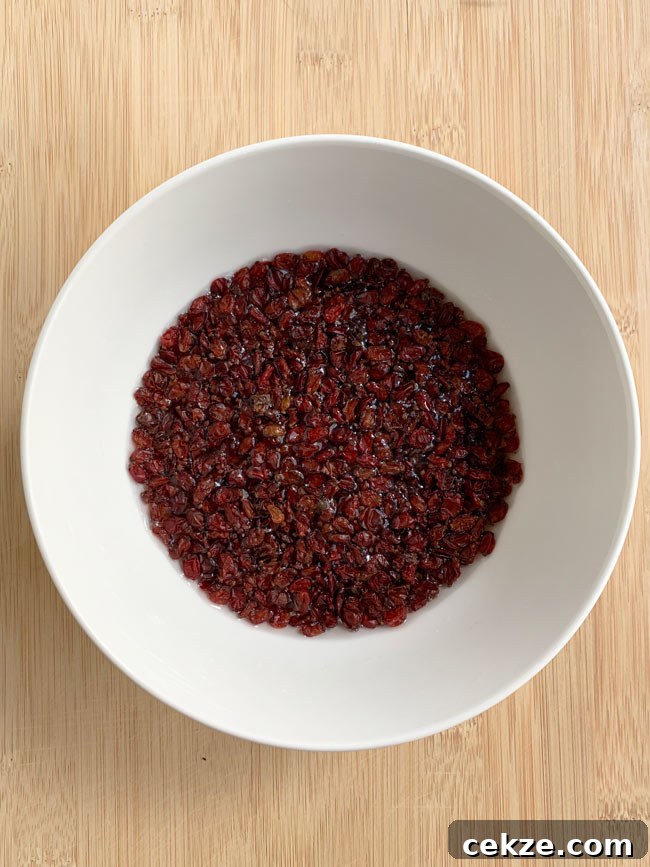 Instant Pot Zereshk Polo — Persian Barberry Rice Recipe 8 Barberries soaking in water in white bowl.