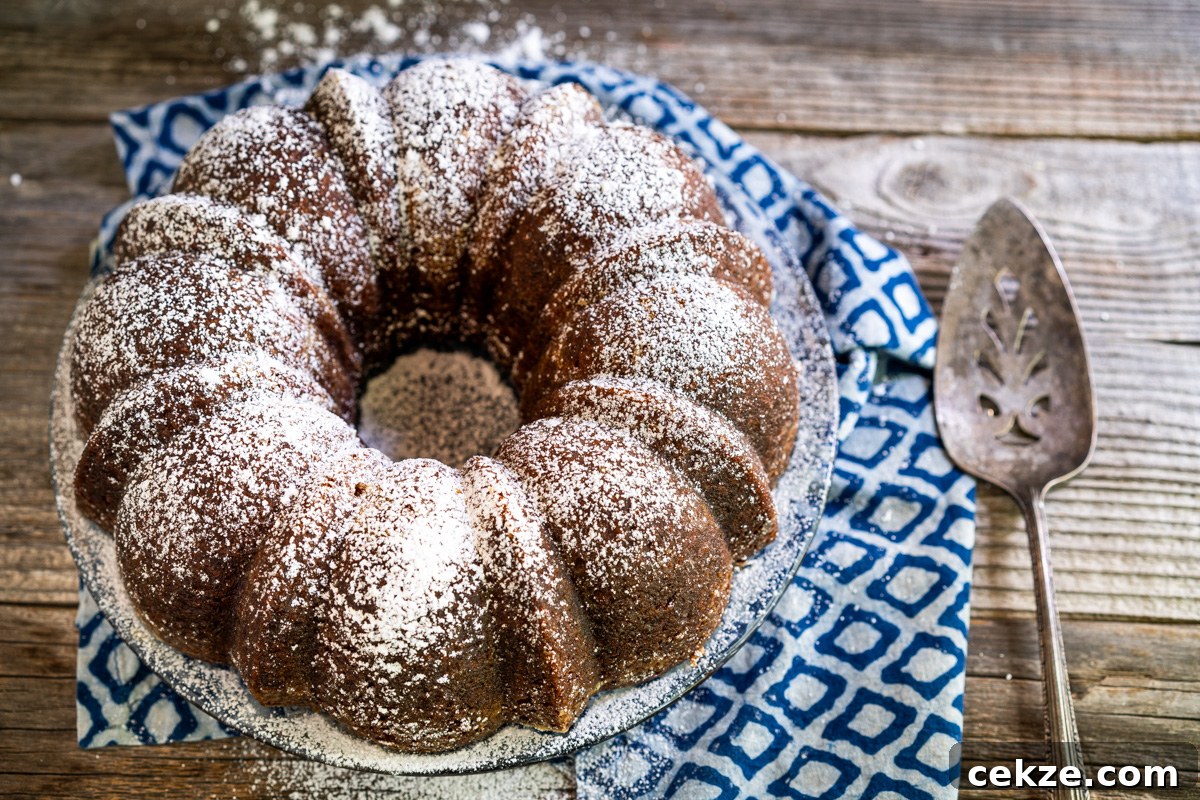 Authentic Cuban Rum Cake Recipe: Moist Drunken Cake with Rum Glaze 2 Top down view of a powdered sugar dusted Cuban Rum Cake sitting on a cake platter. Hostess At Heart