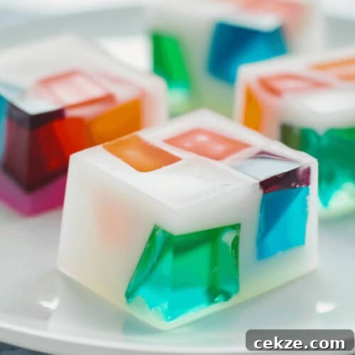 A mosaic of colorful jelly cubes on a white plate.