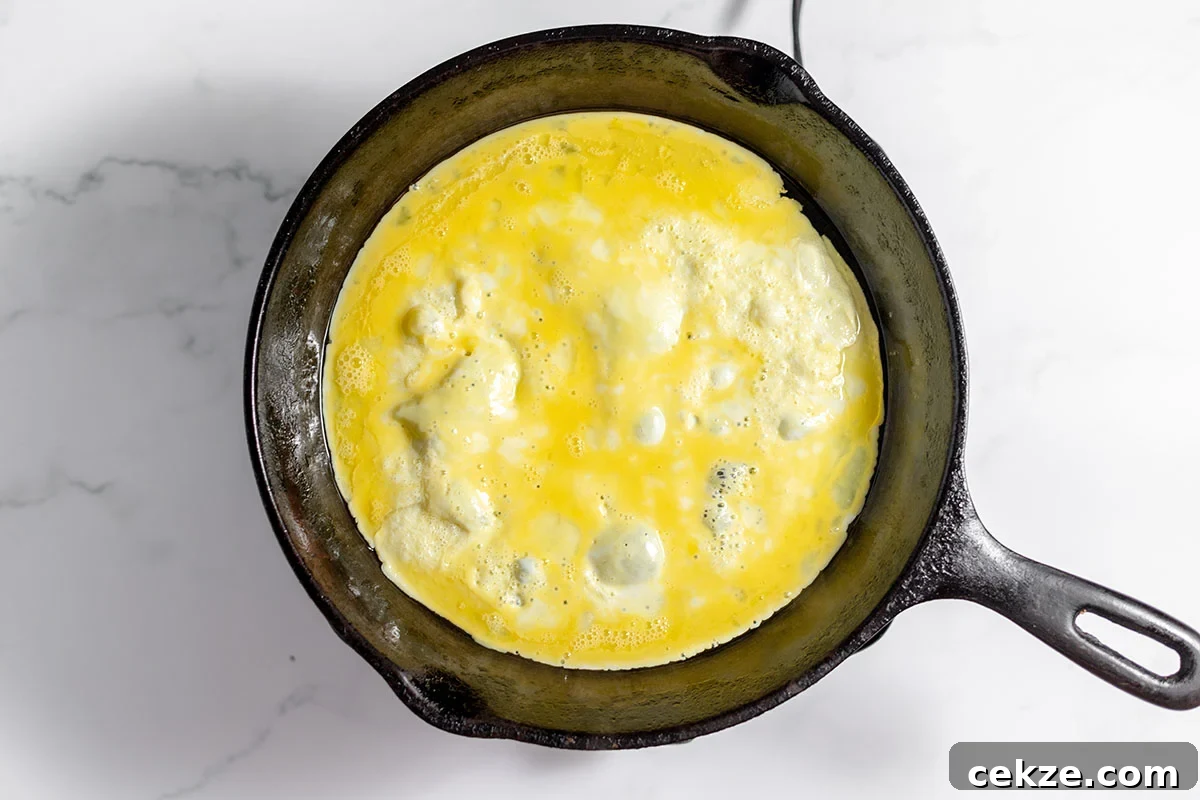 Thin egg omelet in a cast iron skillet.
