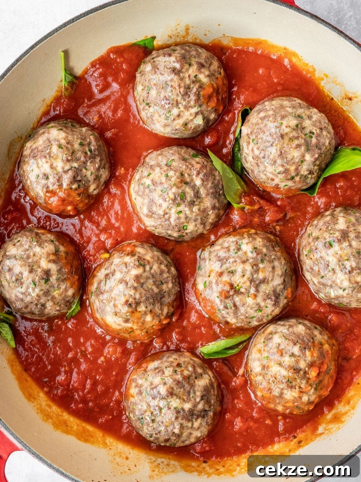 Juicy Italian Meatballs Without Breadcrumbs — Recipe & Tips 7 Adding the marinara sauce to the pan along with fresh basil.