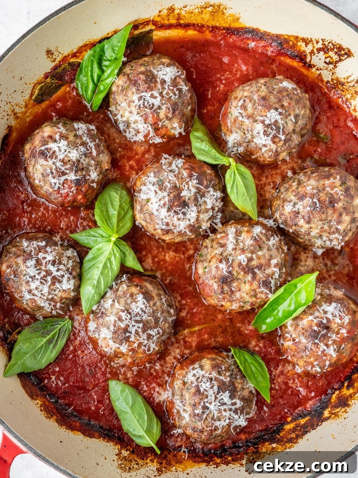 Juicy Italian Meatballs Without Breadcrumbs — Recipe & Tips 9 Italian Meatballs simmering in marinara, garnished with fresh basil and Parmesan.