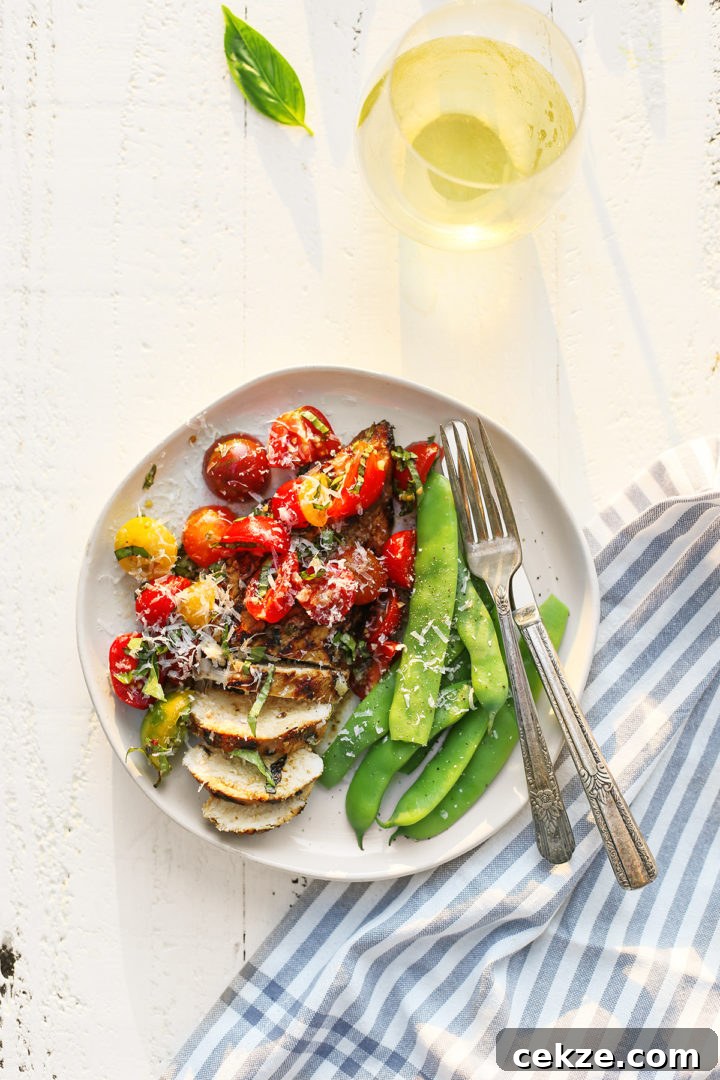 a plate with grilled chicken bruschetta and green beans with a fork and knife
