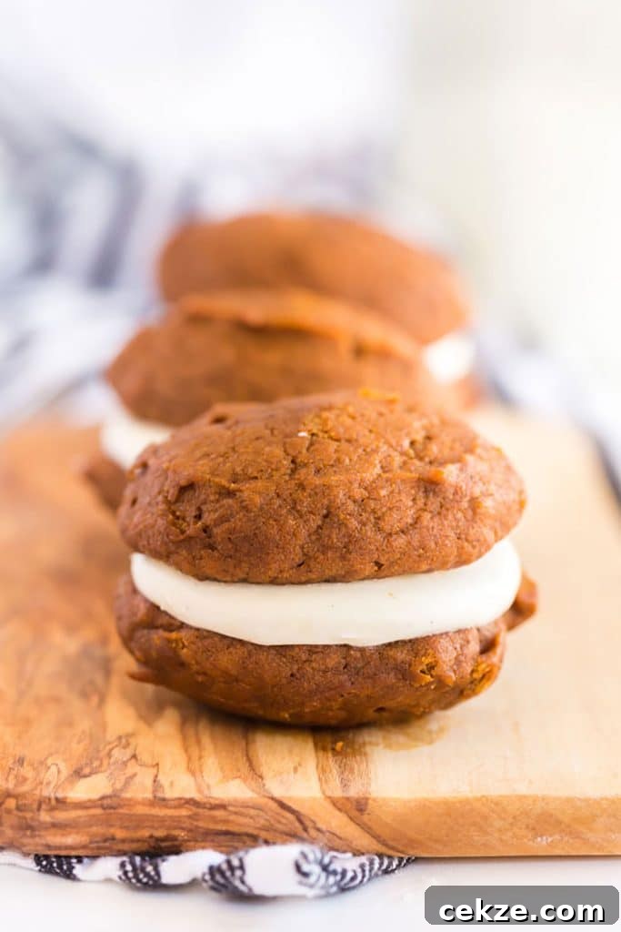 Close up of a pumpkin whoopie pie filled with cream cheese frosting.