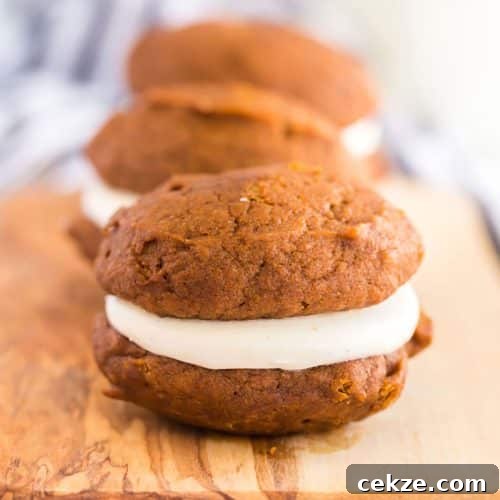 Close up of a pumpkin whoopie pie filled with cream cheese frosting.