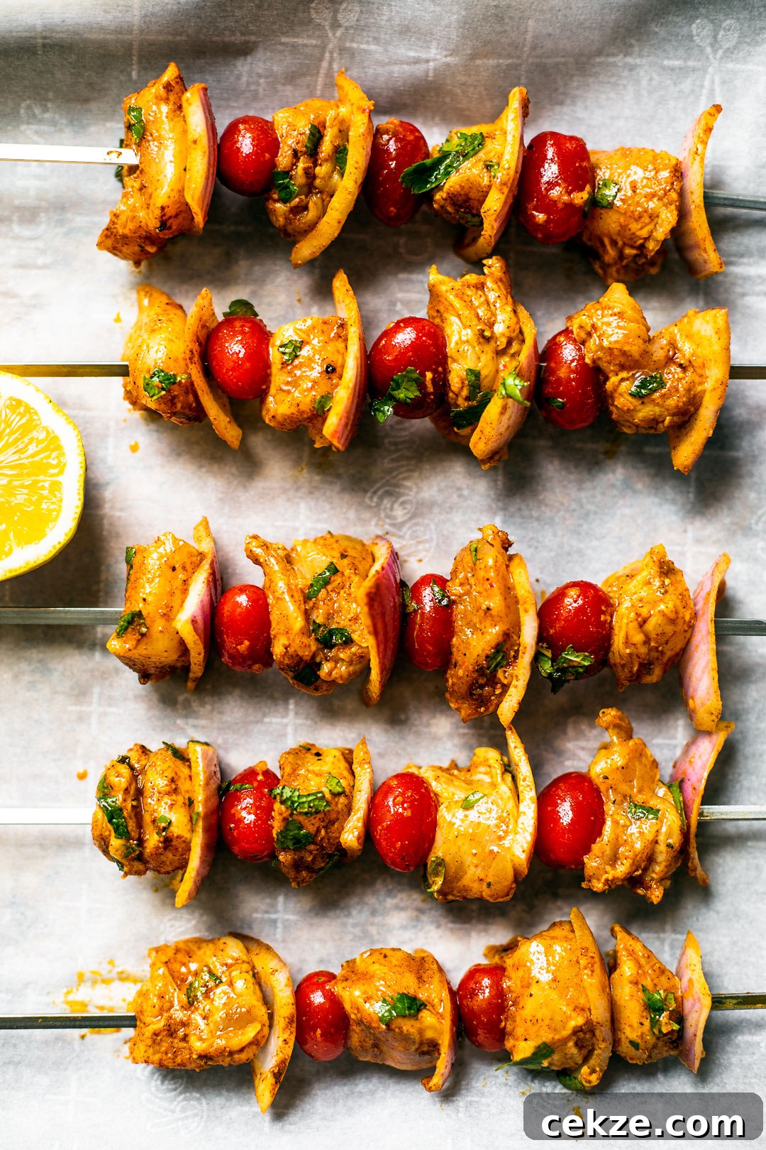Uncooked skewers on parchment paper, seasoned.
