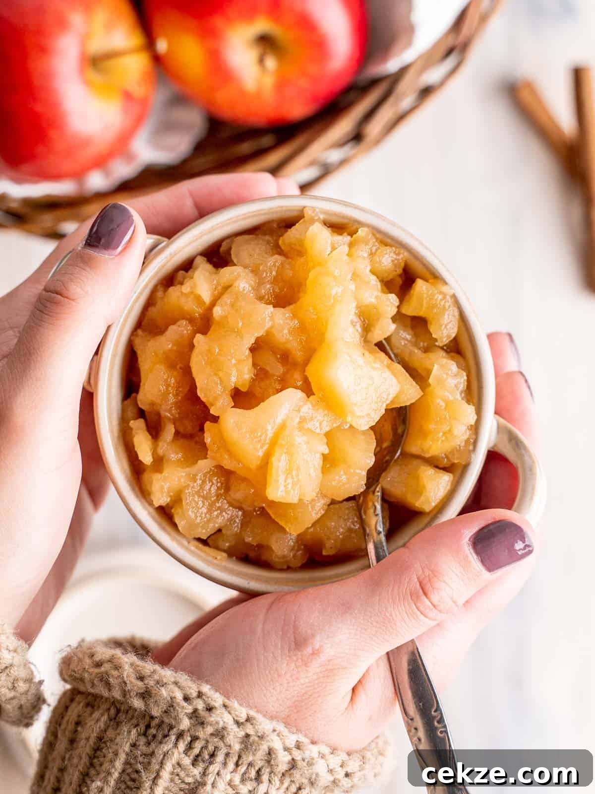 Hands holding homemade chunky applesauce