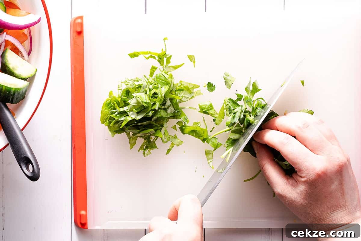 herbs being chopped on cutting board