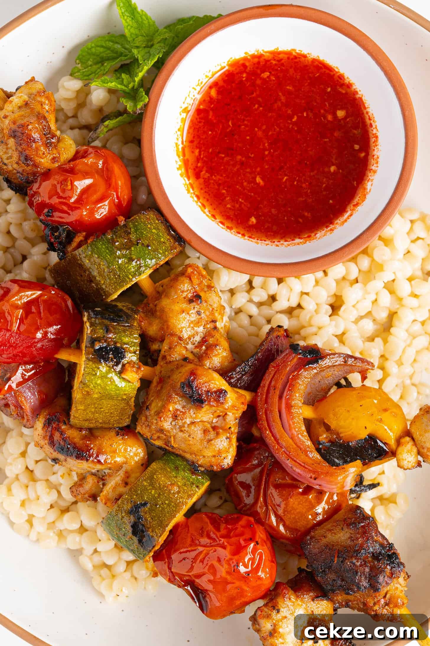 harissa chicken skewers on a plate of couscous
