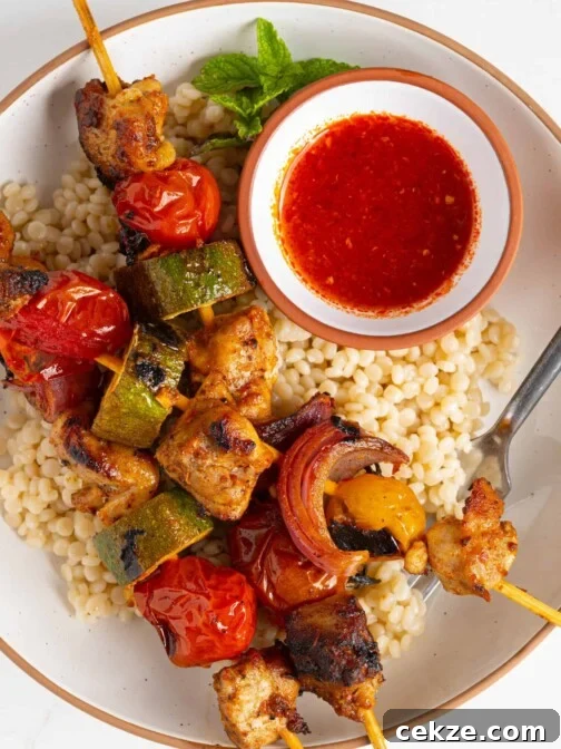 harissa chicken skewers on a plate of couscous