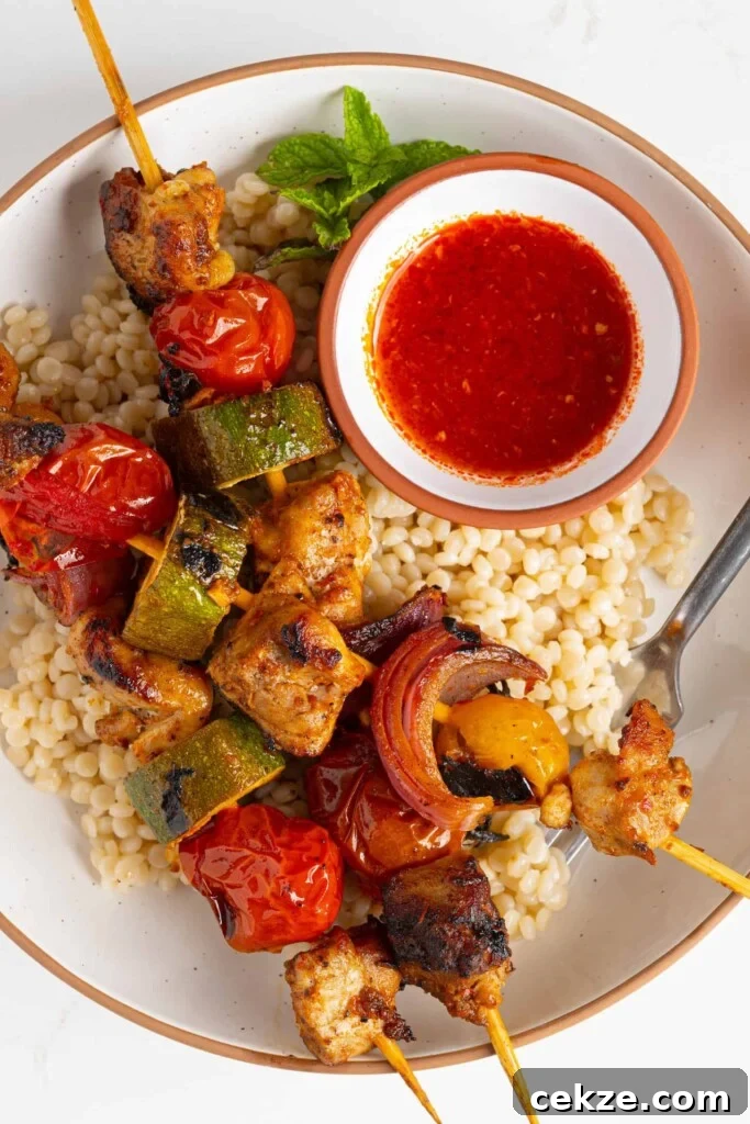 harissa chicken skewers on a plate of couscous